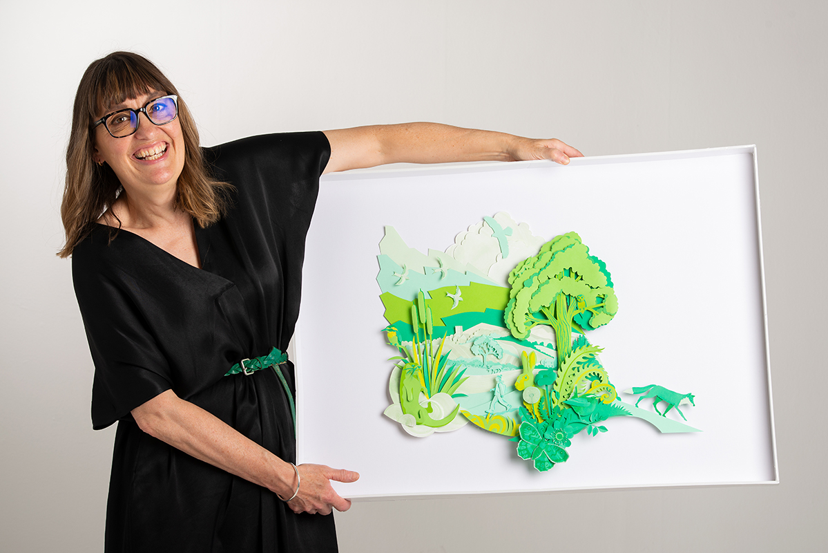 Illustrator Helen Musslewhite pictured with one of her three stunning illustrations produced for the James Cropper Wainwright Prize 2022